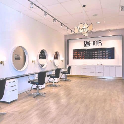 Modern and stylish beauty salon interior in Omaha with circular mirrors and salon chairs.