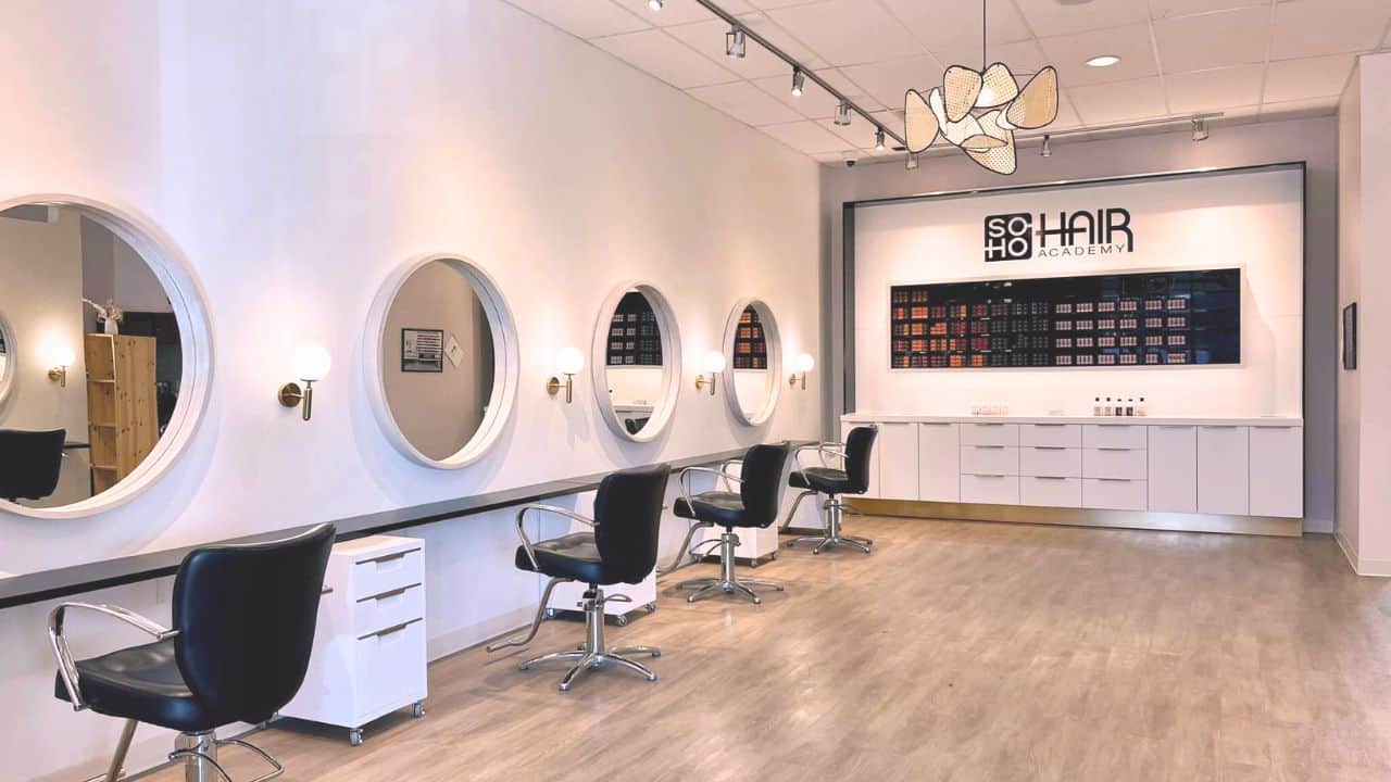Interior of a modern cosmetology school in Omaha with styling chairs, mirrors, and product shelves.