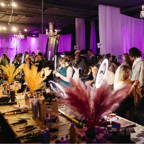 Guests mingling at a salon banquet event with decorative feather centerpieces.