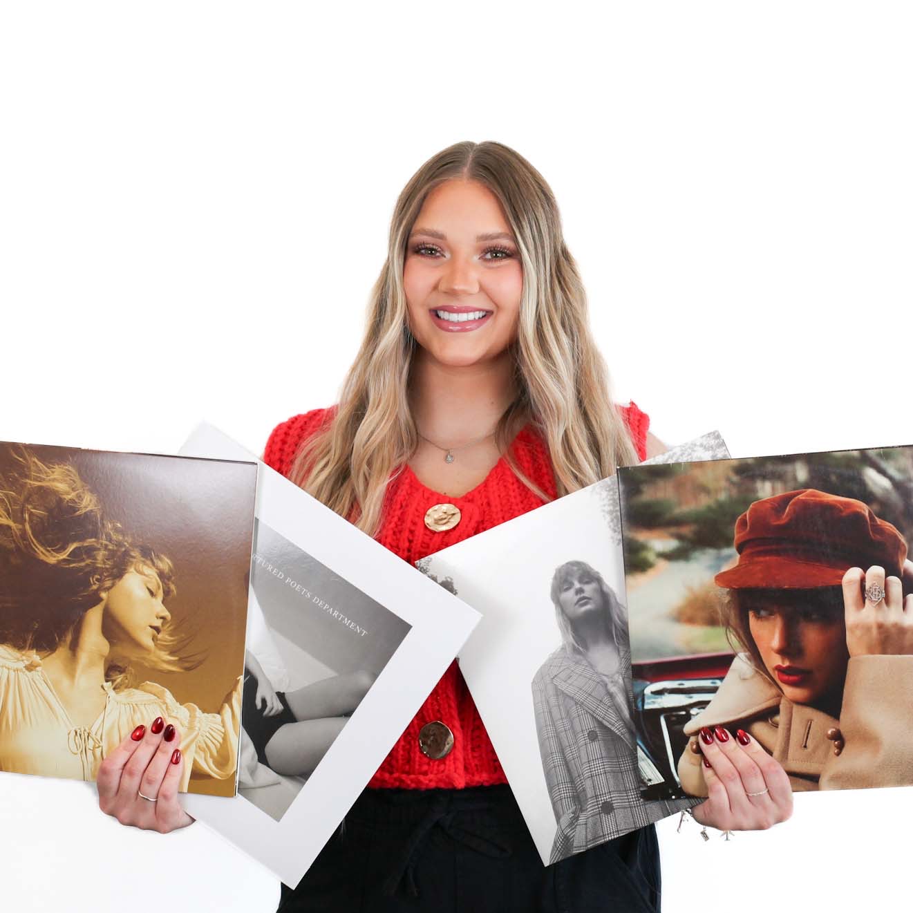 A woman with long blonde hair and a red top holds four vinyl records featuring various female artists on the covers, standing against a white background.