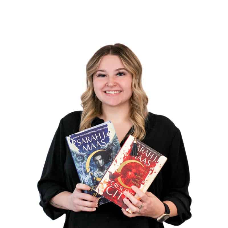 Woman holding two books on cosmetology school with a friendly smile.
