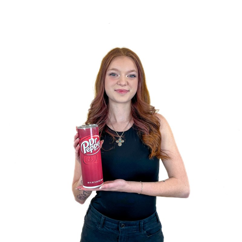 Woman holding a tall can of Dr. Pepper against a plain white background.