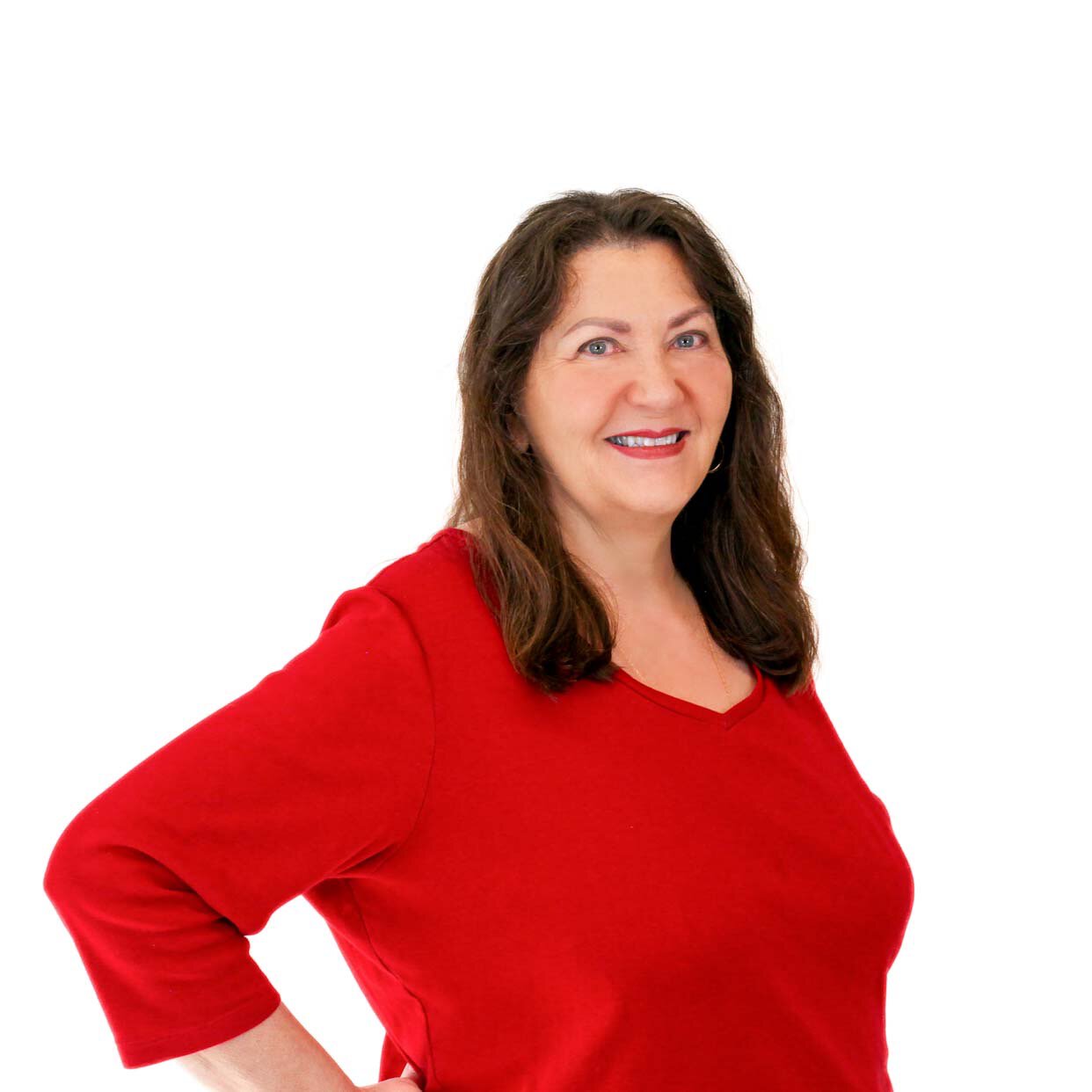 A woman with long brown hair wearing a red shirt, smiling at the camera.