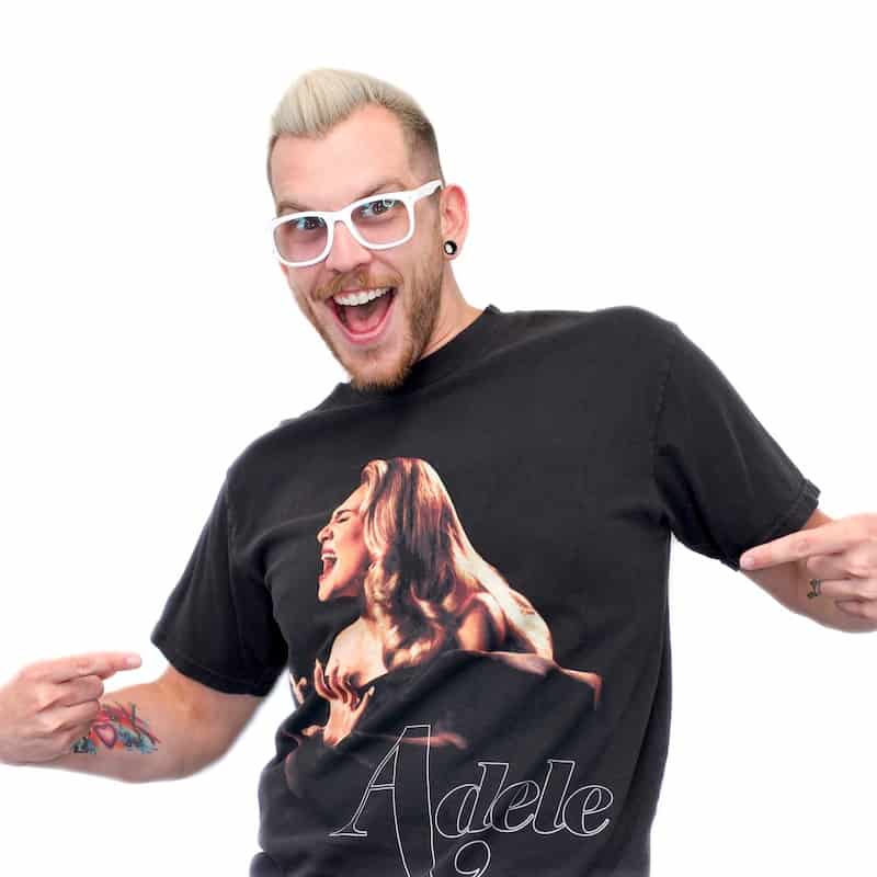 A man with glasses pointing at his T-shirt featuring an image of the singer Adele in Omaha.